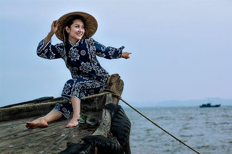 作品描述: 出海作业的渔船回来了,坐在船头等待着亲人归来的渔家姑娘