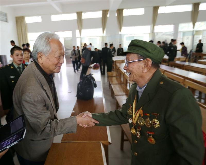 协会员,原山东省文联副主席袁玉森与东方市抗日老战士花江润亲切握手