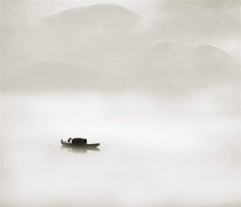 雾气迷蒙的湖面,一叶小舟悠然漂过,俨然就是一幅写意的中国山水画